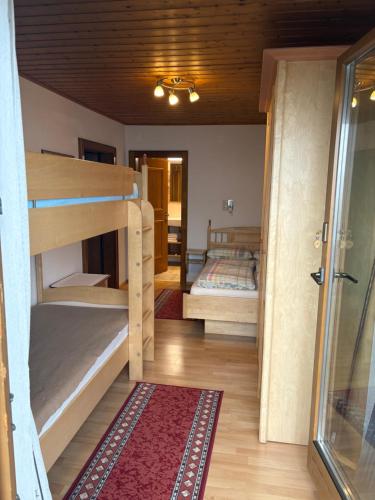 a room with two bunk beds and a hallway at Alpengasthof Eppensteiner in Navis
