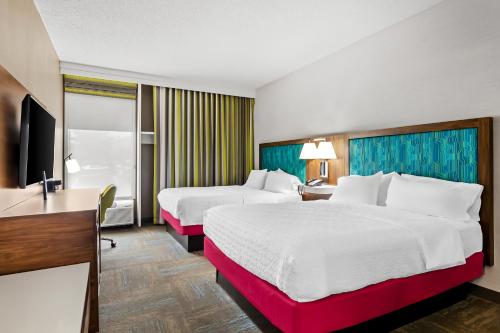 a hotel room with two beds and a flat screen tv at Hampton Inn Princeton in Princeton