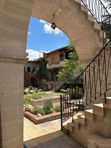 an archway leading to a house with a yard at Mozaik Stone Hotel in Avanos