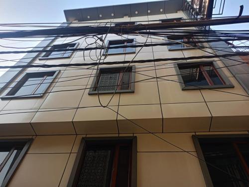 a building with lots of windows and wires at Hotel C G Newly Built 2 Mins From Connaught Place and Railway Station & 5 Mins From VFS Shivaji Stadium Metro Station in New Delhi