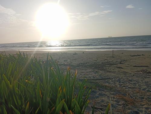 a beach with the sun rising over the ocean at Habitaciones frente al mar in Carretal