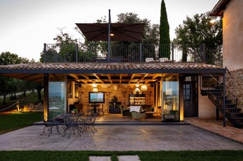 an outdoor patio with a deck with tables and chairs at Casale Isidoro in Castel Ritaldi
