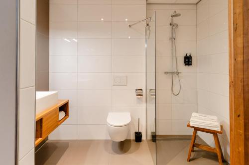 a bathroom with a shower and a toilet and a sink at Boutique Hotel Texel in De Cocksdorp
