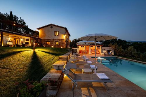 a row of lounge chairs next to a swimming pool at Casale Isidoro in Castel Ritaldi