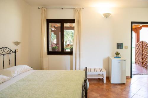 a bedroom with a bed and a window at Agriturismo La Genziana in Alghero