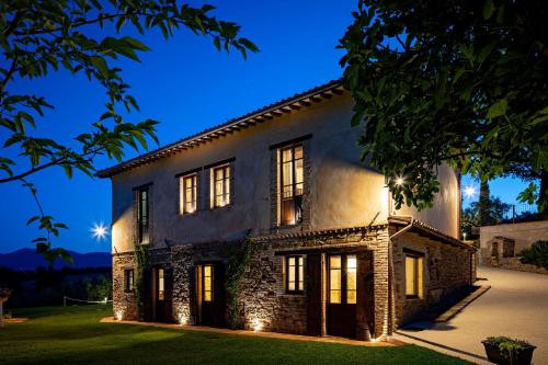 a large brick house with lights on it at night at Casale Isidoro in Castel Ritaldi