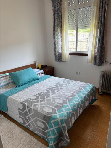 a bedroom with a bed and a window at A casa do Cabezo in Mougás