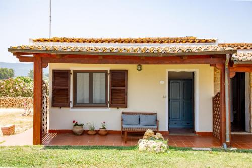 a patio of a house with a blue door at Agriturismo La Genziana in Alghero