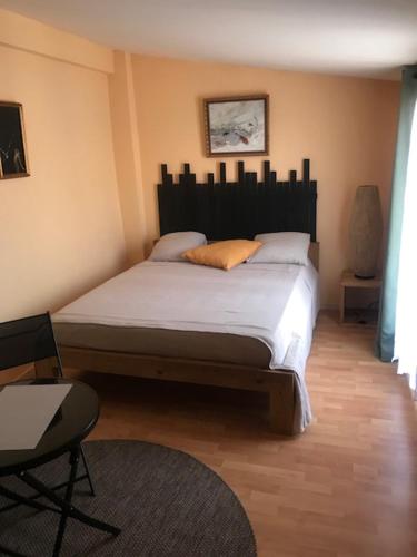 une chambre avec un grand lit dans une pièce dans l'établissement La Pierre De Lave appartement Le Corsaire, à Agde