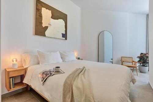a bedroom with a large white bed and a table at Kokomo beachfront in Cotillo