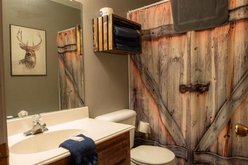 a bathroom with a sink and a toilet and a mirror at Lakeview Room Twin Beds - 21 in Mead