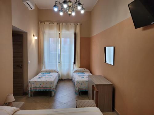 a room with two beds and a chandelier at Casa marina civico 3 in Pizzo