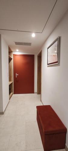 an empty hallway with a red door and a bench at La maison des vignerons - Le Praelatenberg in Orschwiller