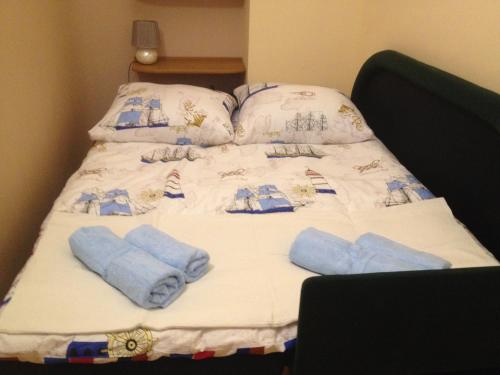 een bed met blauwe handdoeken erop bij Apartament Żeglarski in Kołobrzeg