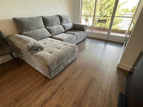 a couch in a living room with a wooden floor at Maravilloso apartamento en Llívia in Llivia