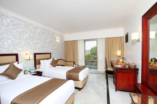 Habitación de hotel con 2 camas y ventana en The Rialto Hotel, en Bangalore