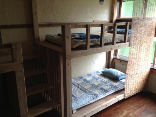 Pokój z 2 łóżkami piętrowymi i łóżkiem w obiekcie Asahi Guest House w mieście Naha