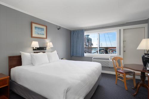 a hotel room with a bed and a desk and a window at Fisherman's Wharf Inn in Boothbay Harbor