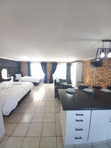 a bedroom with a bed and a living room at Inni Bush Guesthouse in Noordheuwel