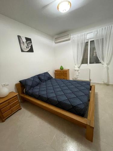 a bedroom with a bed with a blue comforter at Westmorland in Busot