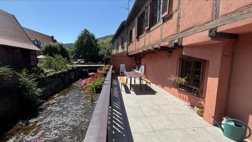 a walkway next to a building with flowers on it at La Maison des Potiers avec Terrasse et Parking in Kaysersberg