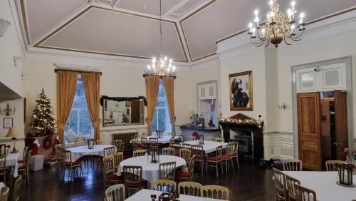 a dining room with tables and chairs and a christmas tree at Craig-Y-Nos Castle in Abercraf