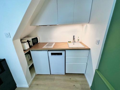 a small kitchen with a sink and a counter at Maison de village - Centre Pérols, terrasse, wifi - Rue calme in Pérols