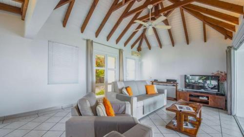 a living room with a couch and a tv at Rustic Romantic Villa with Lovely Ocean Views in Marigot