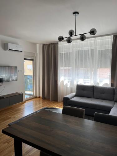 a living room with a couch and a table at LD apartman in Valjevo