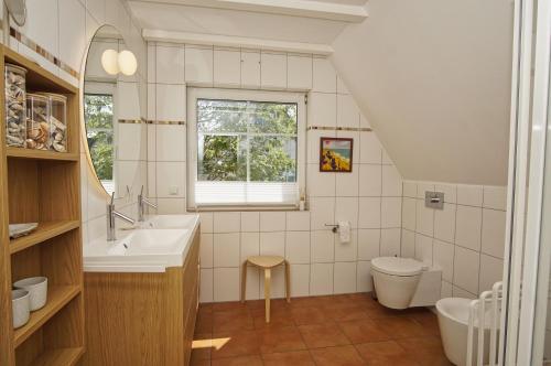 a bathroom with a sink and a toilet at Haus Breeghus Ferienwohnung Seekoje in Breege