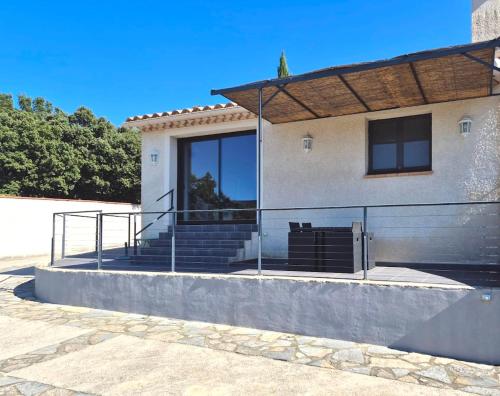 a building with stairs and a fence in front of it at Mas de Cala, gîtes détente au Pic Saint Loup in Saint-Mathieu-de-Tréviers