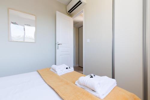 - une chambre avec 2 serviettes blanches sur un lit dans l'établissement VAUBAN appartement Antibes, à Antibes