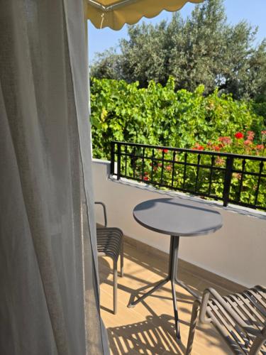 a patio with a table and chairs on a balcony at Pension Zoi in Kolimbia