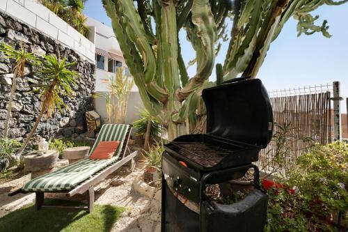 a grill and a bench next to a tree at Pardelo in Los Menores