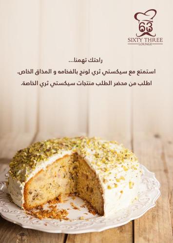 a cake on a plate on a wooden table at SIXTY THREE HOTEL SUiTES in Riyadh