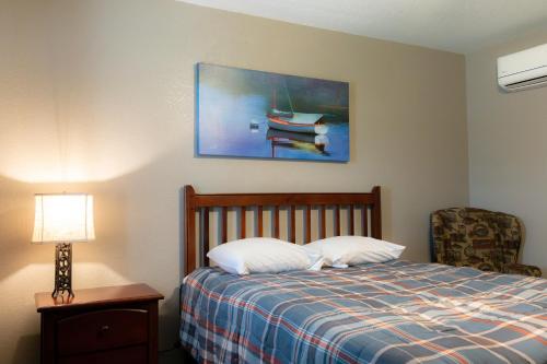 a bedroom with a bed and a picture of a boat at Lakeview Room 2 Queens - 23 in Mead