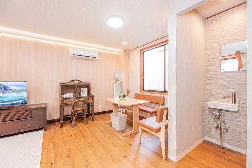 a room with a desk and a table and a sink at Asuka Guesthouse 宿-飛鳥 in Tokyo