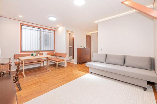 a living room with a couch and a table at Asuka Guesthouse 宿-飛鳥 in Tokyo
