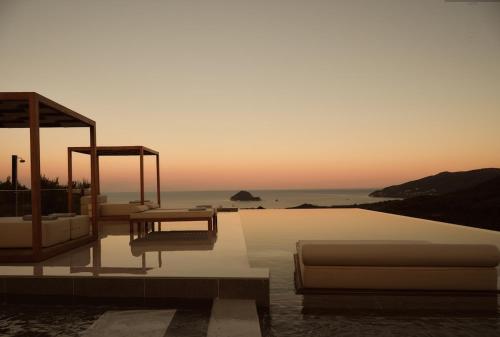 a villa with a swimming pool with a sunset at Marisia Luxury Villa, An Acre of Endless Blue in Lithakia