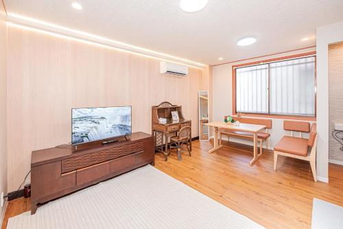 a living room with a television and a table at Asuka Guesthouse 宿-飛鳥 in Tokyo