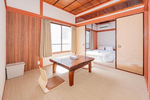 a room with a wooden table and a bed at Asuka Guesthouse 宿-飛鳥 in Tokyo