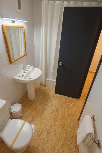 a bathroom with a white toilet and a sink at Rooms Avenida in Tavernes de Valldigna