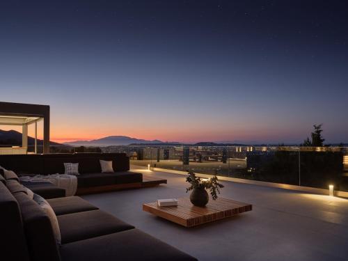 a living room with couches and a view of a city at Marisia Luxury Villa, An Acre of Endless Blue in Lithakia