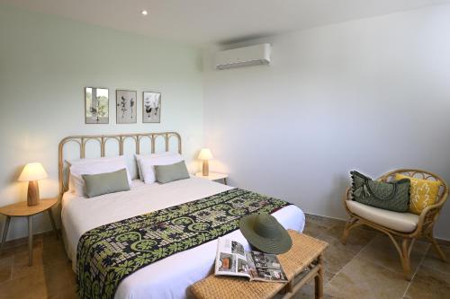 une chambre avec un grand lit et une chaise dans l'établissement La Villa Plein Soleil, à LʼIsle-sur-la-Sorgue