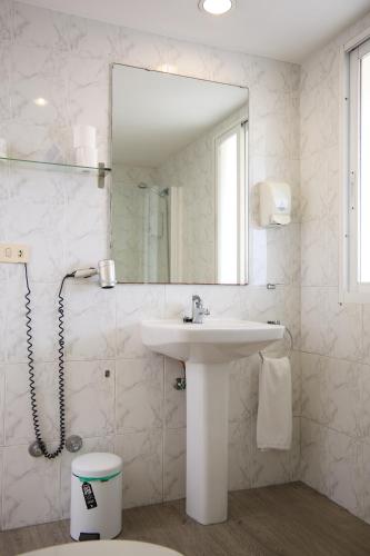 a white bathroom with a sink and a mirror at Hotel Vigo Plaza in Vigo
