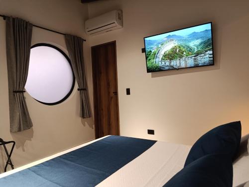 a bedroom with a bed and a tv on the wall at Bluelux Med - B&B in Medellín