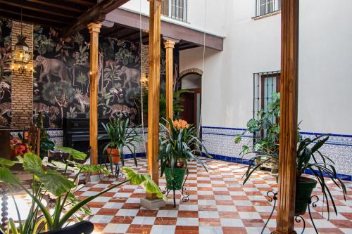 une chambre avec des plantes en pot sur un sol en damier dans l'établissement Casa Señorial Piedrachica, à Séville