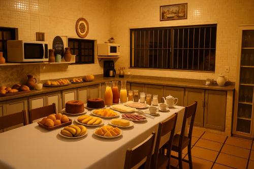 een tafel met eten in de keuken bij Pousada Primavera in Cachoeira Paulista