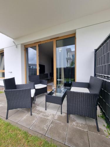 a patio with wicker chairs and a table at Parkowa Premium Apartment in Gdynia