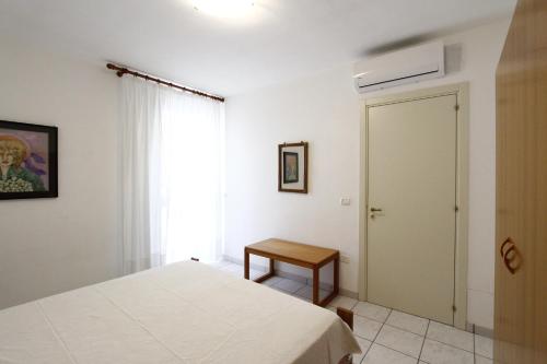 Un dormitorio con una cama y una mesa y una ventana. en Residence La Villa 303, en Leuca